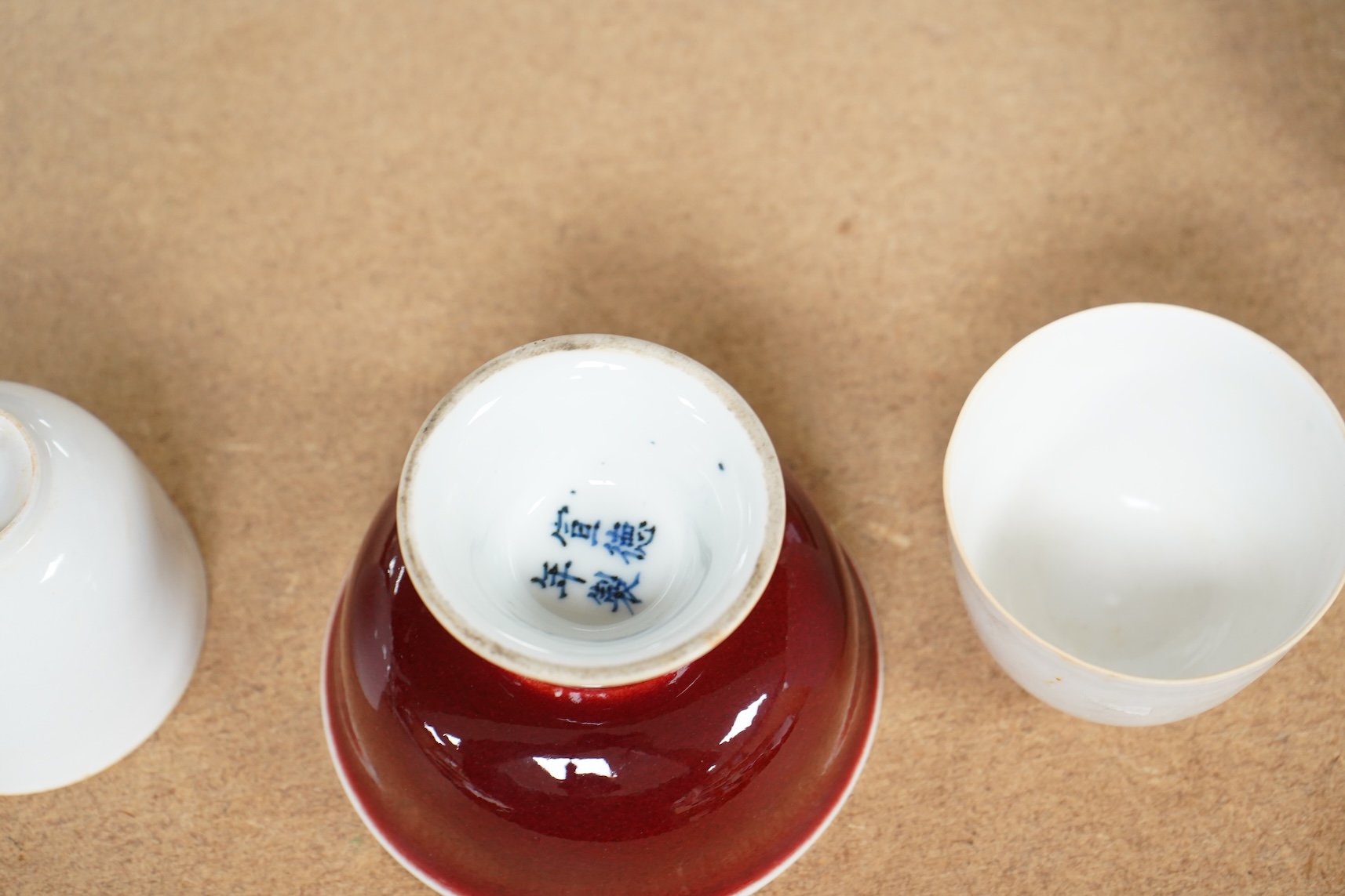 A Chinese red glazed stem cup together with two white glazed tea bowls, tallest 6.5cm